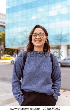 Young woman, with backpack, headphones, ready to start university. Medium shot photography. Royalty-Free Stock Photo #2268650289