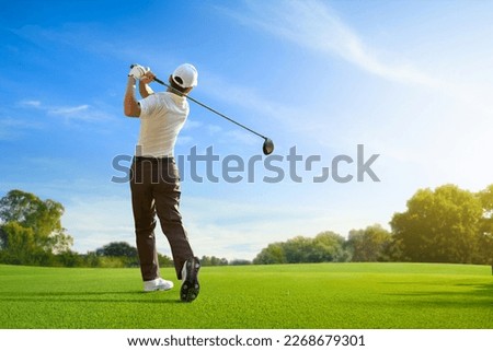 Golfer hit sweeping driver after hitting golf ball down the fairway. Royalty-Free Stock Photo #2268679301