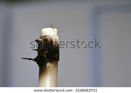 Substandard materials of ledtube a led tube light neon lamp, a burnt led lamp tube due to bad materials, substandard materials concept, hazards of light lamps, fire and industrial security concept Royalty-Free Stock Photo #2268682931