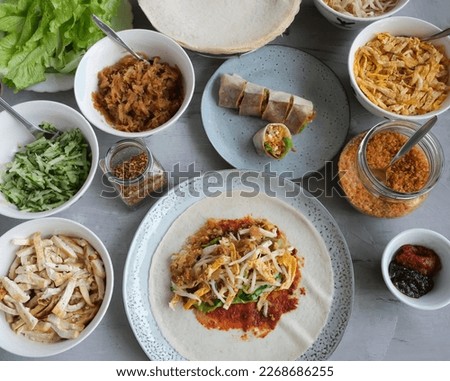 Homemade Chinese meal. Popiah or Popia. It's a roll or wrap consisting of a thin wheat flour skin, spread with spicy and savoury sauce, filled with fresh, dried, cooked ingredients, a popular snack