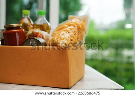 Foodstuffs in donation box for volunteer to help people. Royalty-Free Stock Photo #2268686475