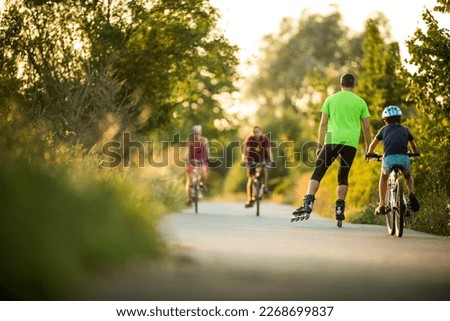 People doing sports on a biking path in the evening Royalty-Free Stock Photo #2268699837