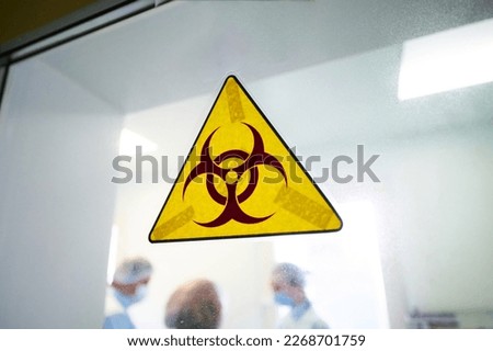 Biohazard warning sign on transparent laboratory door Royalty-Free Stock Photo #2268701759
