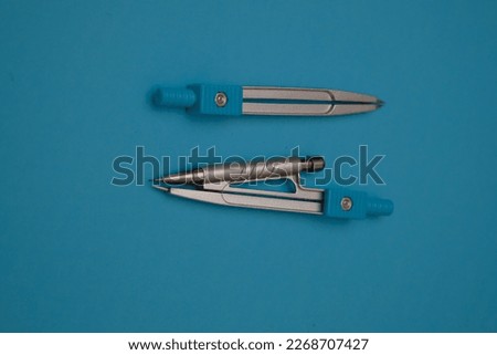 drawing compass,on blue background with clipping path. Selective focus