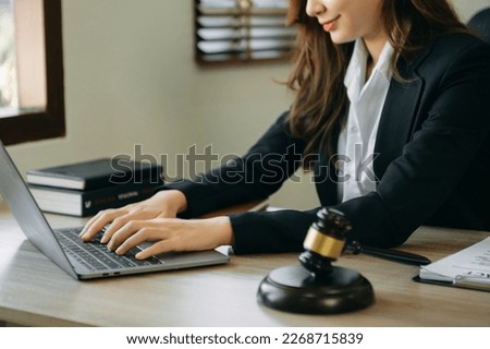 justice and law concept.female judge in a courtroom on wooden table and Counselor or female lawyer working in modern office. 