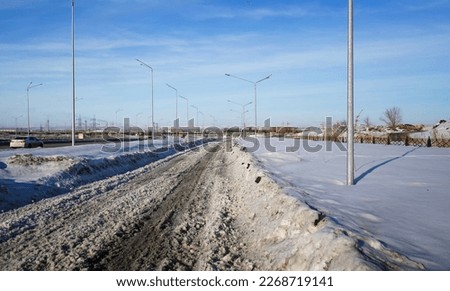 One of the streets of the city. Urban landscape. Springtime. Melting snow. City outskirts. New residential area. Ust-Kamenogorsk (kazakhstan)