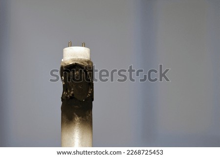 Substandard materials of ledtube a led tube light neon lamp, a burnt led lamp tube due to bad materials, substandard materials concept, hazards of light lamps, fire and industrial security concept Royalty-Free Stock Photo #2268725453