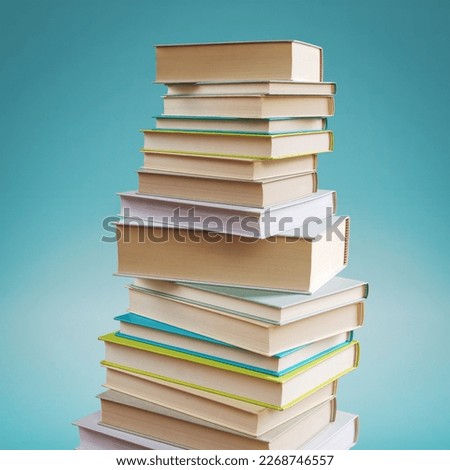 Many stacked books on blue background, learning and reading concept