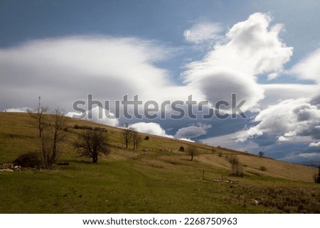 Old farm on steep slope landscape photo. Nature scenery photography with soft puffy clouds on background. Ambient light. High quality picture for wallpaper, travel blog, magazine, article