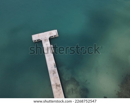 High-angle shot of a wooden bridge stretching in the middle of the emerald sea