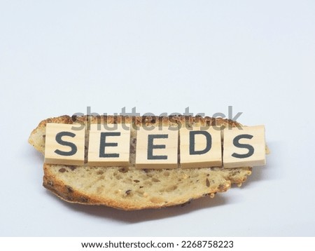 Wooden letters with the word "SEEDS" on a slice of bread