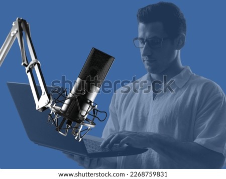 Microphone near man with laptop. Blogger hosting audio podcasts. Condenser microphone on tripod. Man is typing text on keyboard. Blogger radio host on blue. Microphone for recording podcasts