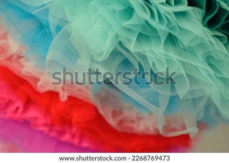 draped background of colorful powdery fabric in the form of tulle, texture textile surface. Texture background from the airy fabric of the dress. Copy space for text about design and fashion. 