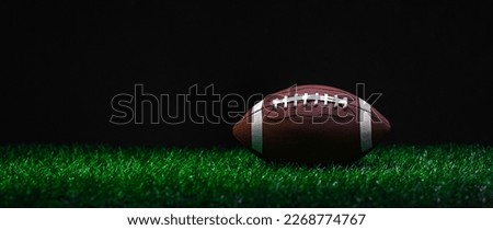 American football on green grass, on black background. Horizontal sport theme poster, greeting cards, headers, website and app
