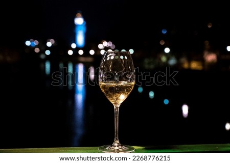 Tasting of french sparkling white wine with bubbles champagne outdoor at night with view on Marne river and lights of Epernay city in winter, France