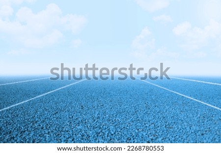 Blue running track with separate white line in straight area Royalty-Free Stock Photo #2268780553