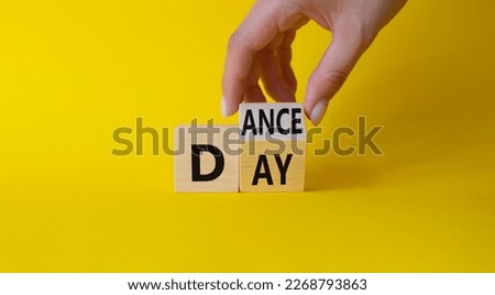 International Dance Day symbol. Businessman hand turns wooden cubes with words Dance day. Beautiful yellow background. International Dance Day concept. Copy space.