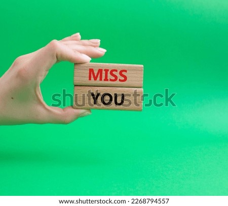 Miss you. Concept word Miss you on wooden cubes. Beautiful green background. Businessman hand. Business and Miss you concept. Copy space.