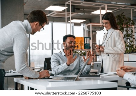 Men and woman are working in the office together.