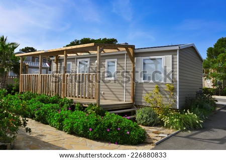 a nice mobile home with a wooden veranda in a campsite Royalty-Free Stock Photo #226880833
