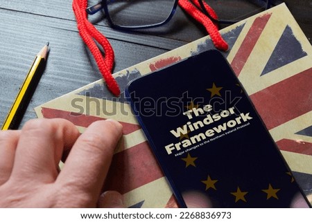 Windsor framework agreement concept: smartphone over a paper bag on a wooden table Royalty-Free Stock Photo #2268836973