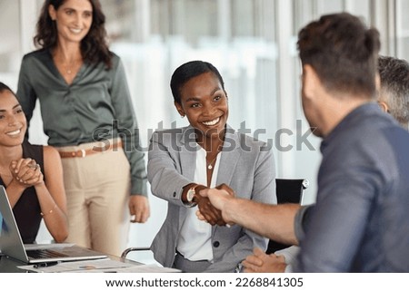 Happy black businesswoman and businessman shaking hands at meeting. Professional business executive leaders making handshake agreement. Happy business man closing deal at negotiations. Royalty-Free Stock Photo #2268841305