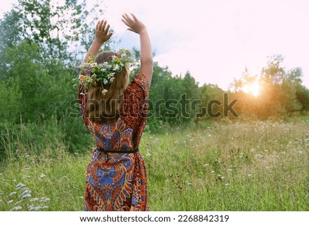 girl in flower wreath on meadow, abstract green natural background. Floral crown, symbol of summer solstice. ceremony on Midsummer, wiccan Litha sabbat. pagan slavic holiday Ivan Kupala Royalty-Free Stock Photo #2268842319