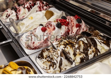 Tubs of ice cream of various flavors photographed in an ice cream parlor ready to be sold Royalty-Free Stock Photo #2268842753