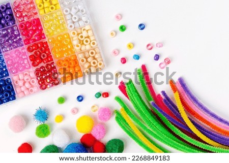Set for children's crafts. Pipe Cleaners, beads and colorful pom-poms. Different multi-colored supplies and materials for DIY art activity for kids. Motor skills, creativity and  hobby. Royalty-Free Stock Photo #2268849183