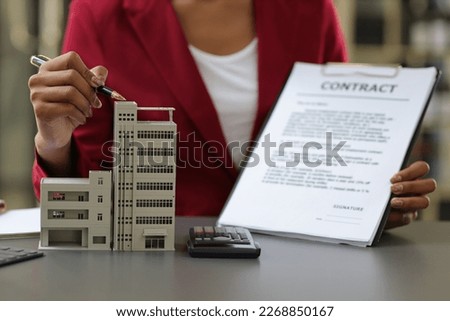 African businesswoman, real estate agent presenting residential building and house sale contract to sign.