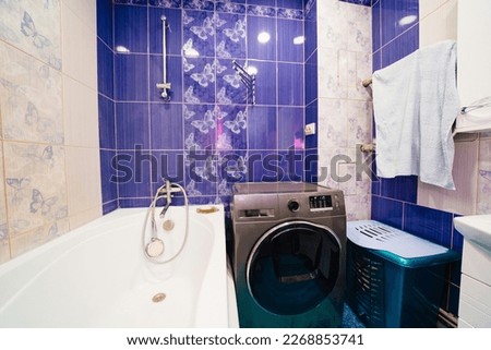 bathroom interior with blue ceramic tiles on the walls. outdated, non-modern repairs in the apartment. Royalty-Free Stock Photo #2268853741