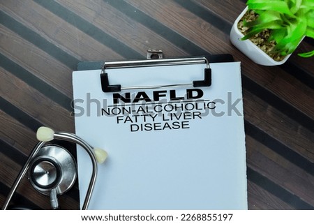 Concept of NAFLD - Non-Alcoholic Fatty Liver Disease write on paperwork with stethoscope isolated on Wooden Table. Royalty-Free Stock Photo #2268855197