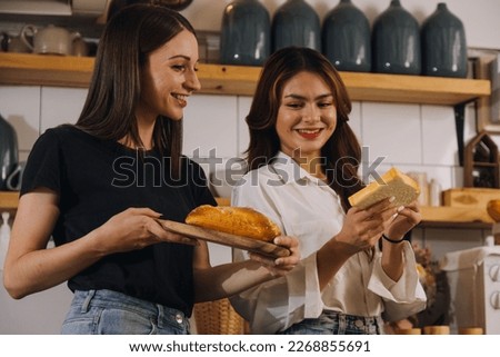 Young woman eating pizza and laughing while sitting with her friends in a restaurant. Group of friends enjoying while having food and drinks at cafe.
