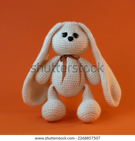 handmade toy rabbit on orange background