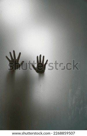 Left and right hand shadow blur behind frosted glass.shadow of hands behind frosted glass

