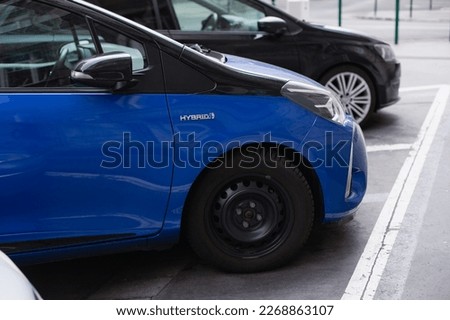 hybrid sign on blue car on the parking