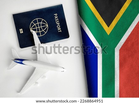 Flag of South Africa with passport and toy airplane. Flight travel concept  Royalty-Free Stock Photo #2268864951
