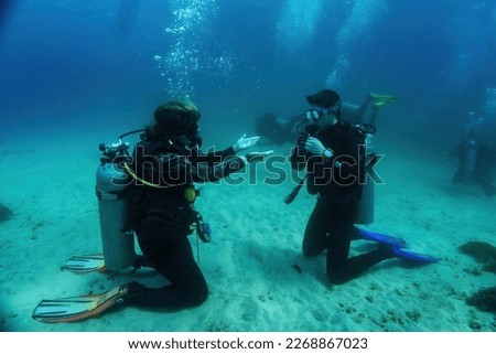 Underwater Scuba dive course training. Unidentified dive master explains with gestures what has to be done during the underwater dive lesson. Bali, Indonesia Royalty-Free Stock Photo #2268867023