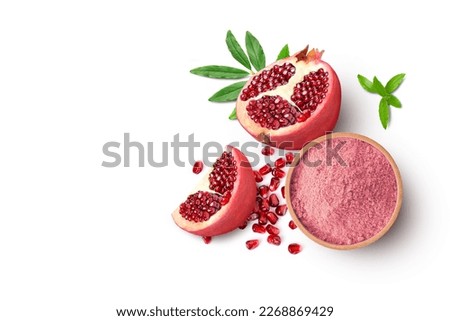 Pomegranate powder in wooden bowl and fresh fruit isolated on white background. Top view, flat lay. Royalty-Free Stock Photo #2268869429