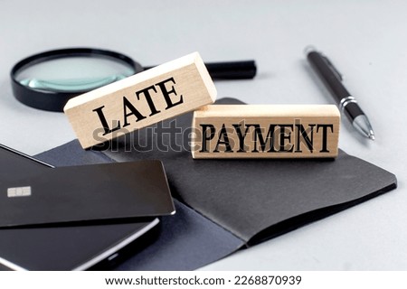 LATE PAYMENT text on a wooden block on black notebook , business concept Royalty-Free Stock Photo #2268870939