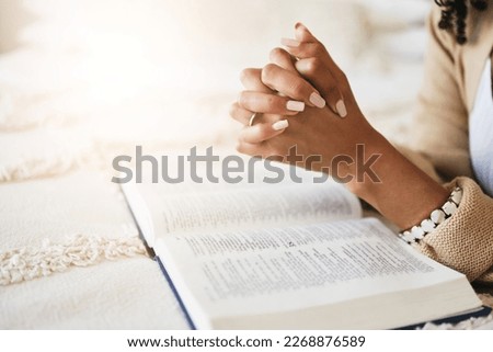 Prayer, bible and hands praying for religion, hope or help, spiritual or faith in home. God, christian and female or woman worship Jesus Christ or Holy Spirit with catholic text or book for peace. Royalty-Free Stock Photo #2268876589