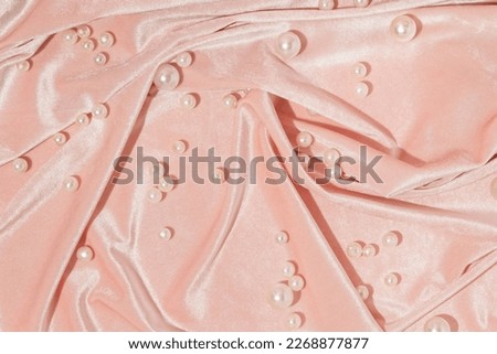 Creative layout with pearls on pastel pink velvet background. 80s or 90s retro fashion aesthetic concept. Minimal romantic idea.