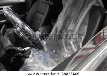 Put on protective covers when taking the car in service. Steering wheel with protective cover on. Car pre-sale Royalty-Free Stock Photo #2268885003