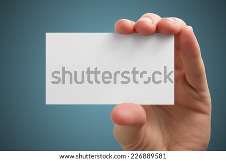 Hand holding a business card on a blue background