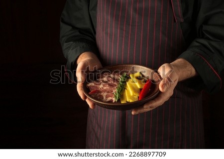 The waiter serves a plate of sliced ham and cheese. Dark space for recipe or menu.