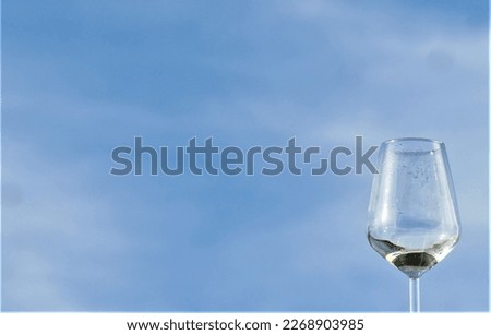 Glass with drink on blue sky background