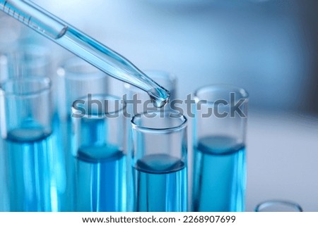 Dripping liquid from pipette into test tube in laboratory, closeup Royalty-Free Stock Photo #2268907699
