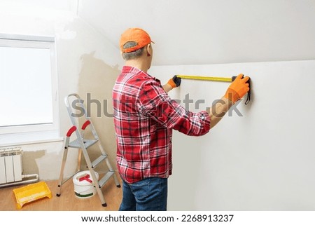 Man taking measurements while working on renovation of apartment. Do it yoursef concept. Royalty-Free Stock Photo #2268913237