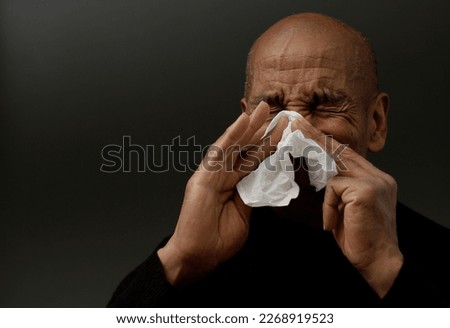 catching the flu man blowing his nose after catching a cold on grey background with people stock image stock photo