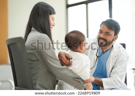 A kind doctor who treats pediatric patients. The child and his family brought him to see the doctor at the hospital because he was ill. Royalty-Free Stock Photo #2268919809
